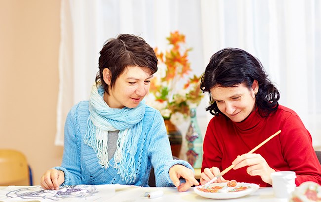 Women sitting at table doing crafts