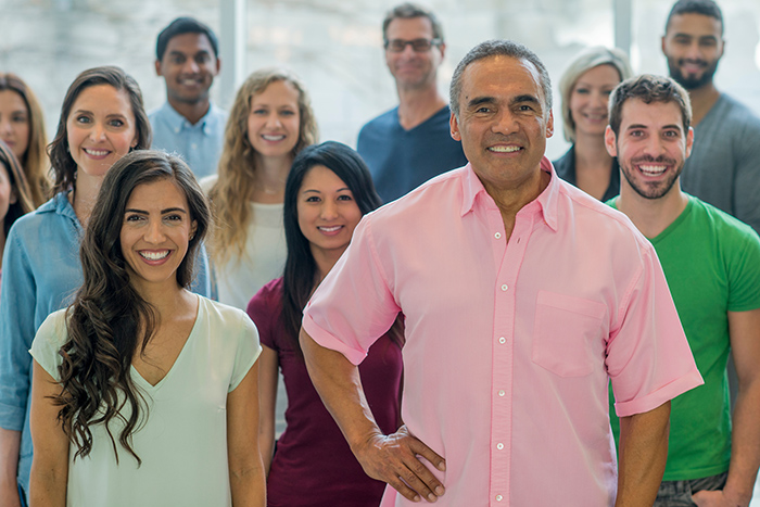 Group of men and woman smiling at the camera inside an office