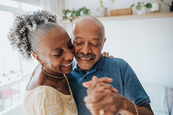 Older man and woman dancing inside house
