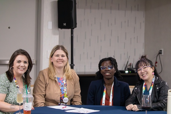 Group of four smiling attendees sitting at a table at AOTPAC night at AOTA INSPIRE 2026