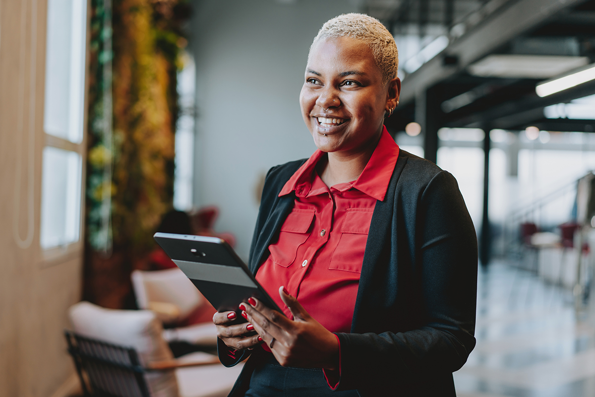 Smiling woman standing with a tablet in her hands