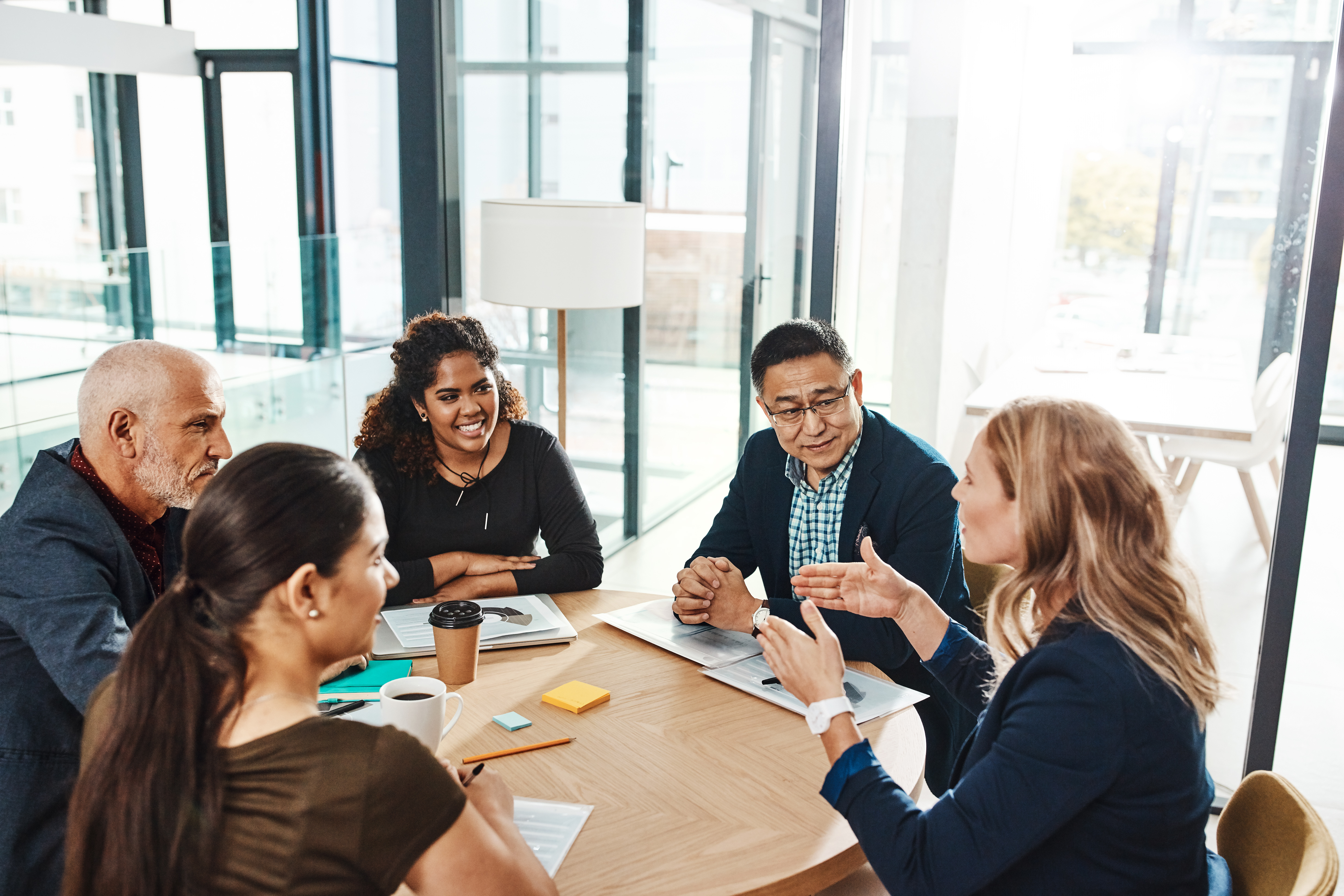 Diverse group of professionals meeting around a table.