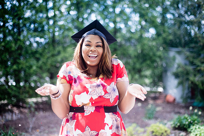 Happy female college student outside wearing graduation cap
