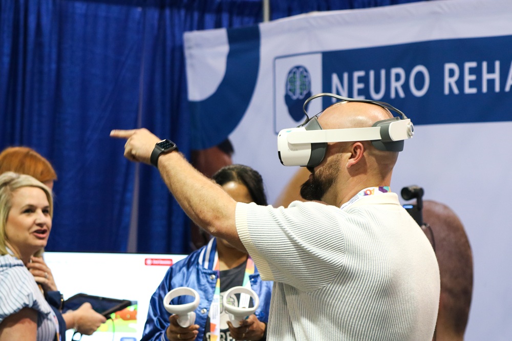 Person uses an exhibitor's device at an AOTA specialty conference