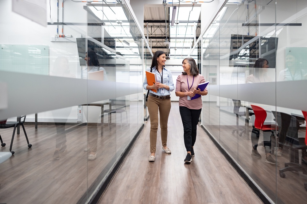 Two educators walking and talking in a hallway between classrooms