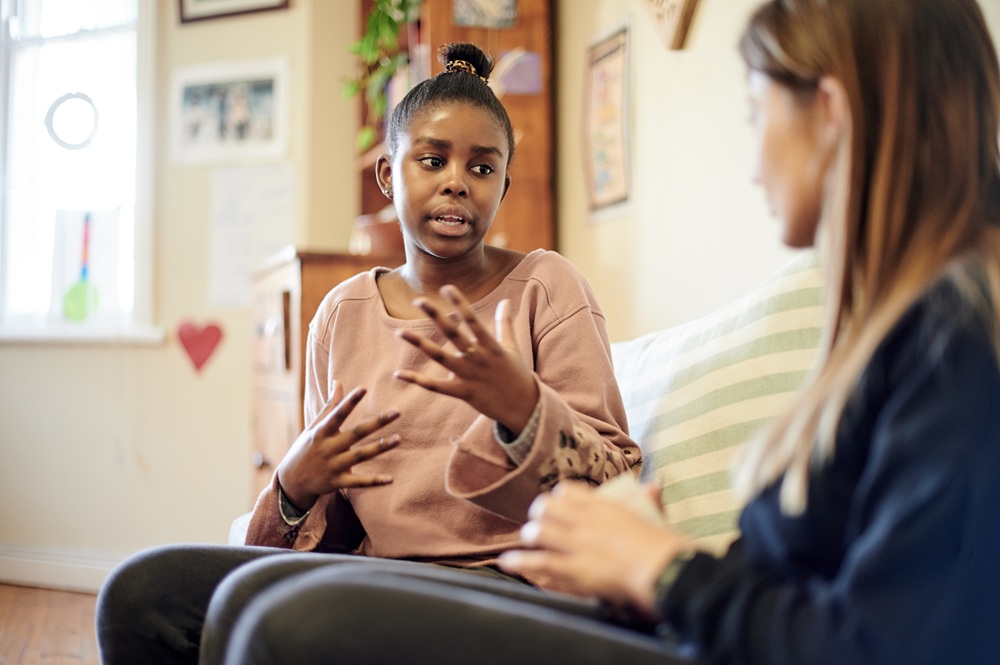 Woman sitting on couch talking with OT practitioner