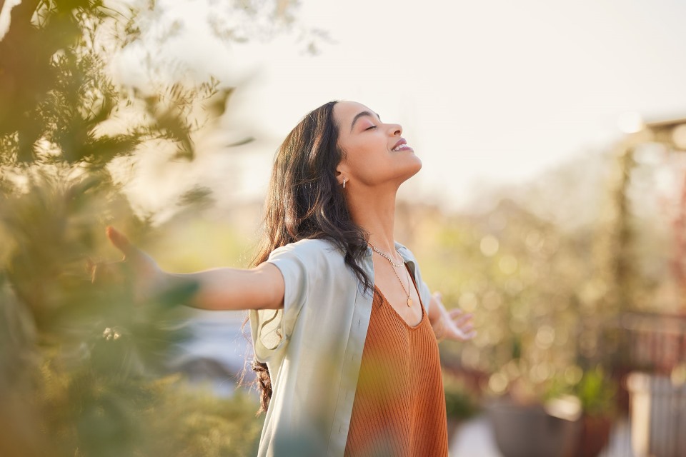 Woman standing outside with arms outstretched