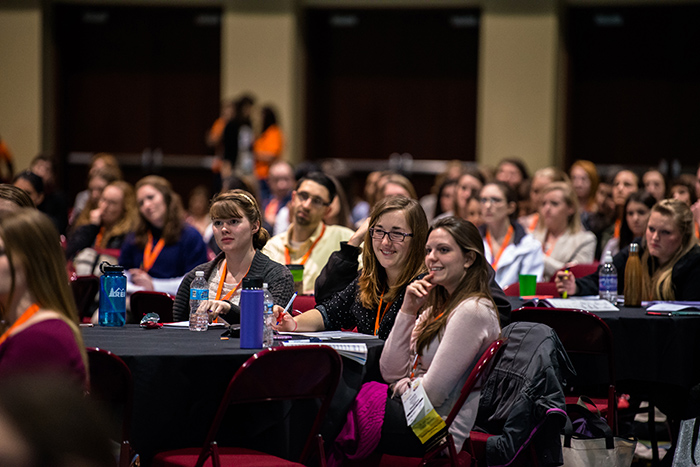 Large room full of AOTA Annual Conference and Expo attendees sitting around tables listening to speaker