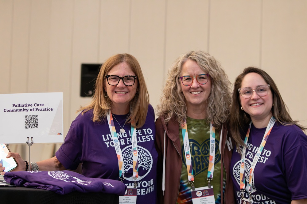 Three women at INSPIRE 2026 near a Communities of Practice table at the SIS Networking Reception