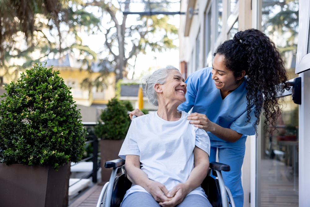 Occupational therapy practitioner assisting older adult in wheelchair
