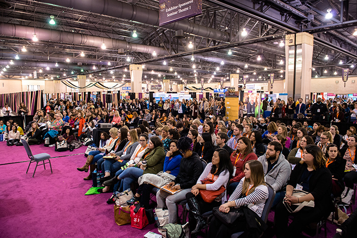 Crown of AOTA Annual Conference and Expo attendees sitting in expo hall listening to sponsor session