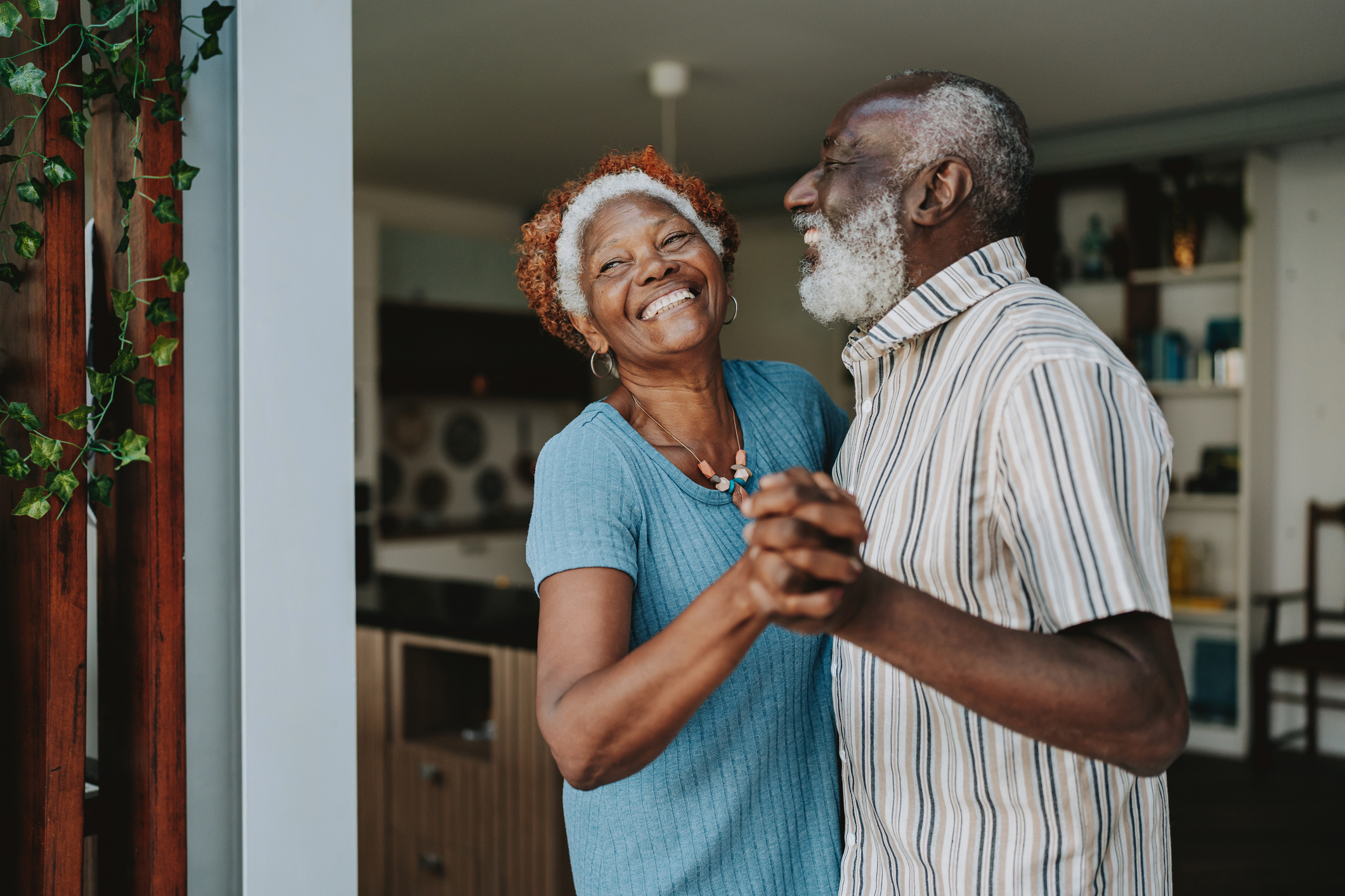 Image of an older African American couple smiling and dancing.
