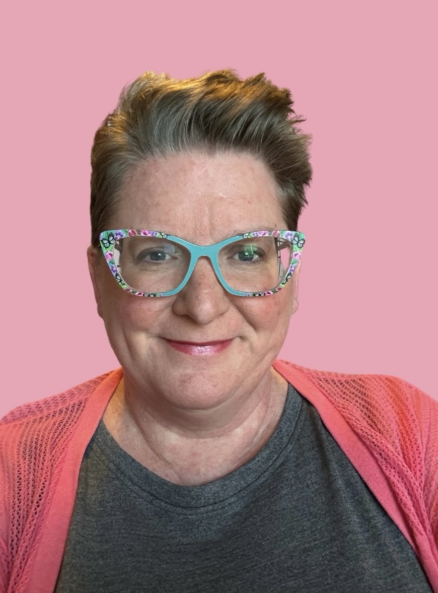 Karla Reese sitting-smiling-blue-glasses
