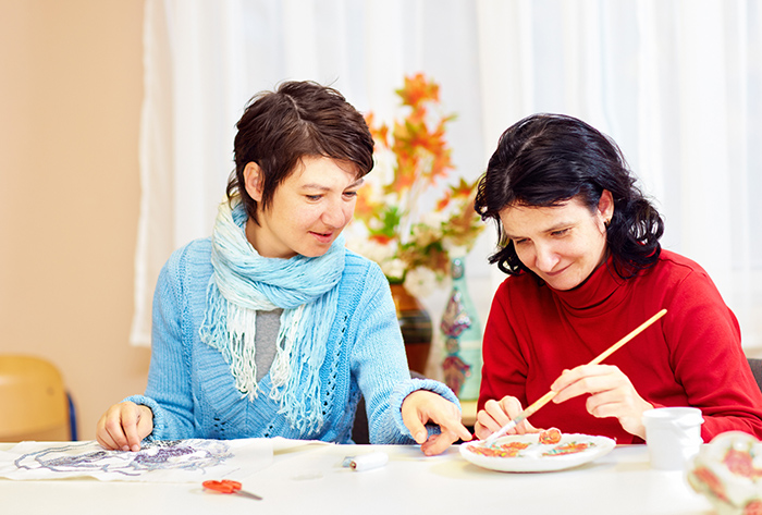 Women sitting at table doing crafts