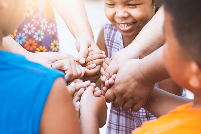 Group of children holding hands with focus on smiling girl