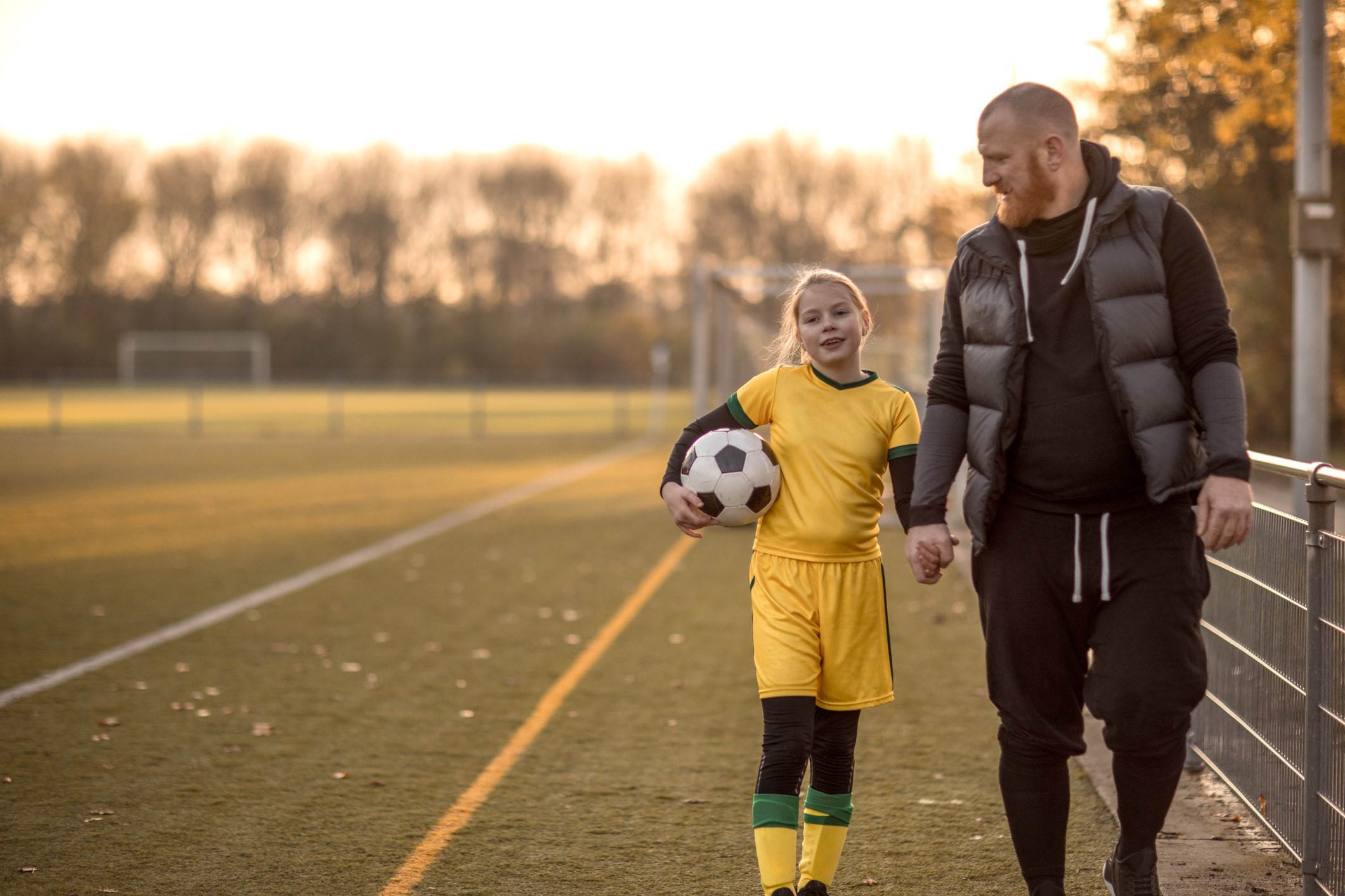 father-walking-with-daughter-outside-after-soccer-2