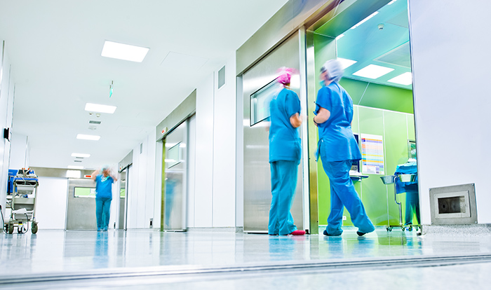Hospital hallway with blurred healthcare workers wearing scrubs talking