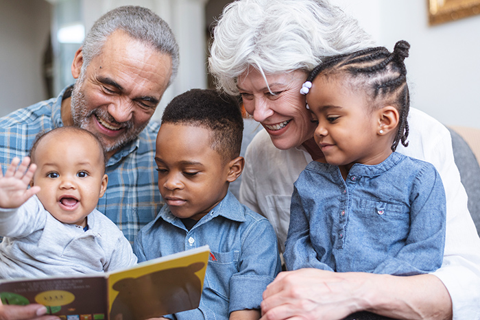 Older man and woman reading to three small children