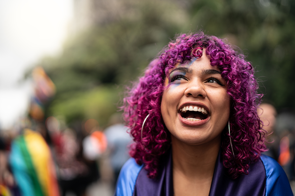 lgbtqia-smiling-young-person-outside-with-purple-hair