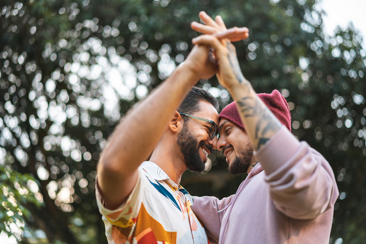 lgbtqia-two-people-smiling-and-dancing-outside