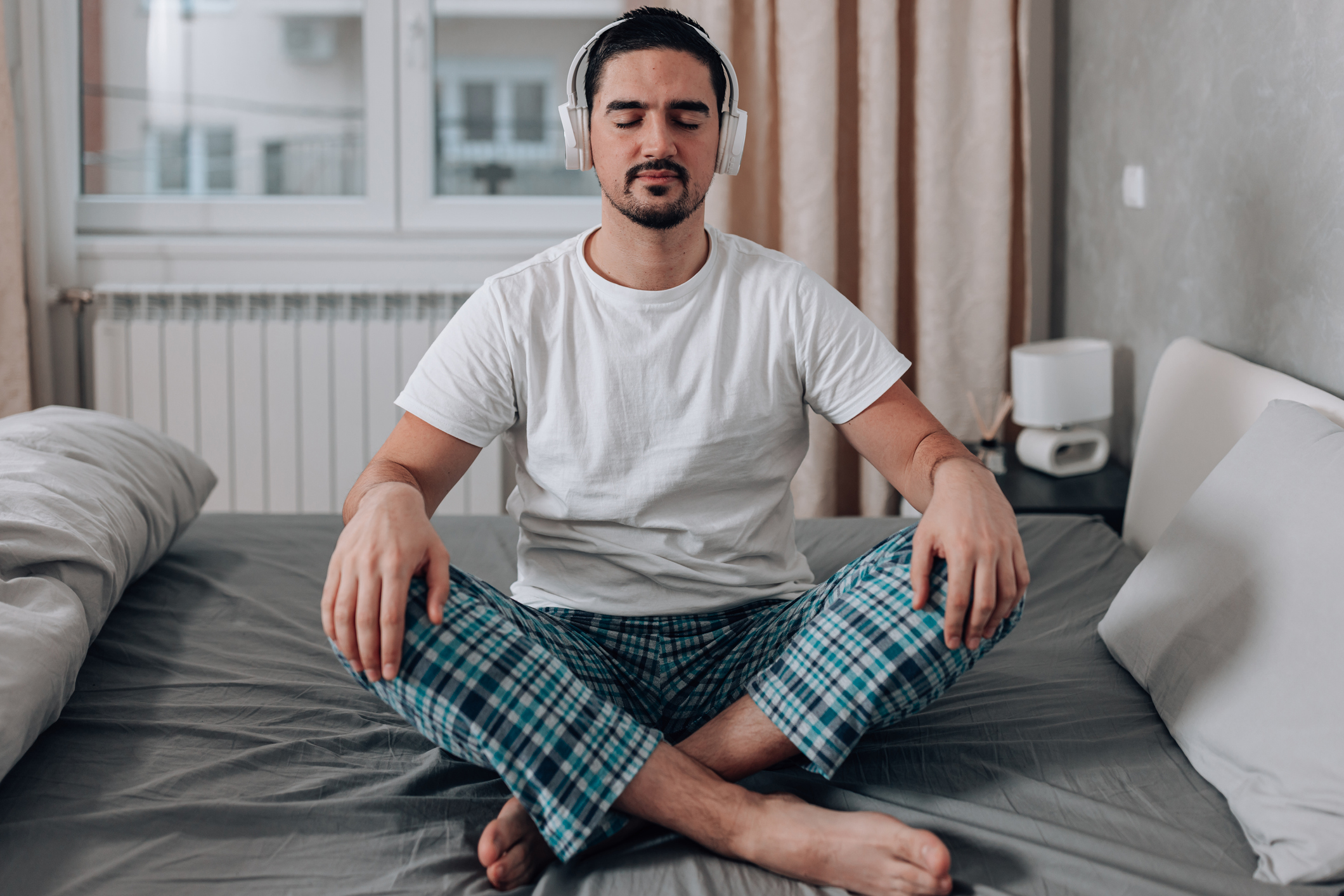 Person sitting cross-legged in bed meditating