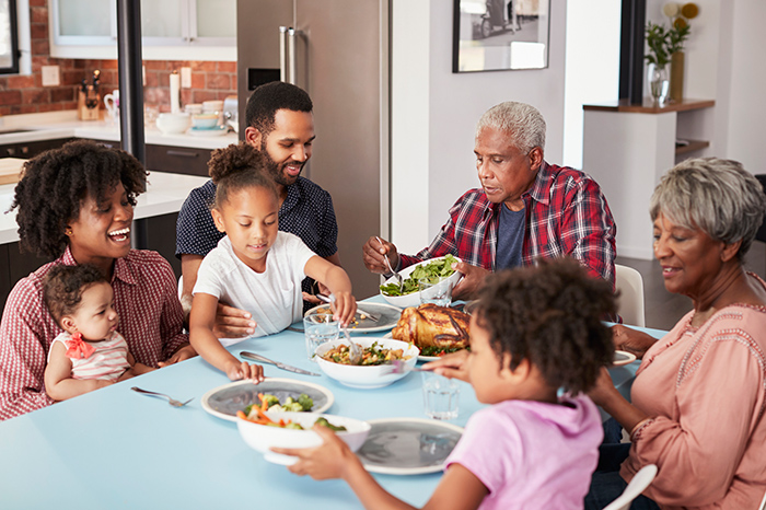 Large family sitting around the dinner table eating together