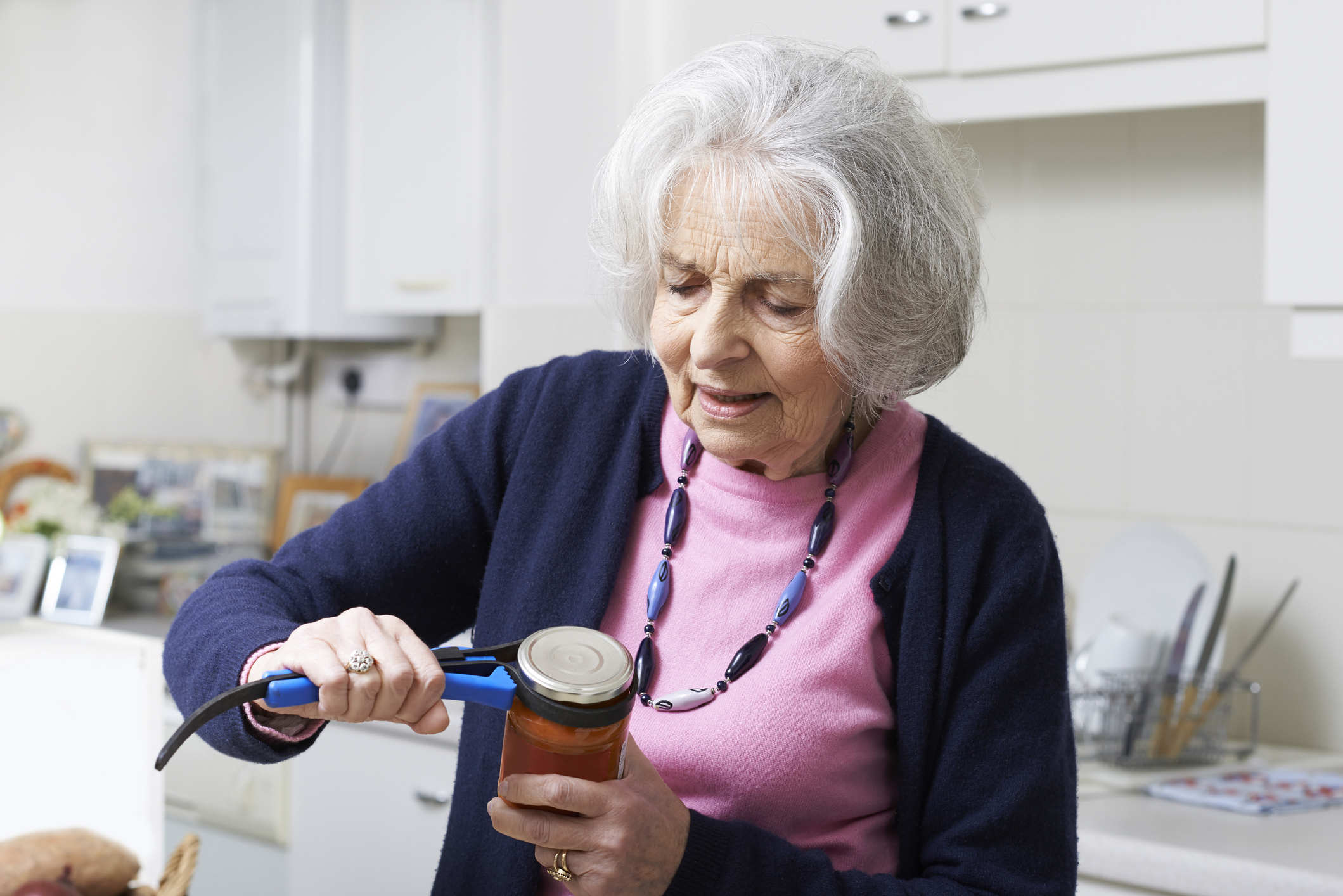 Older woman using jar opener
