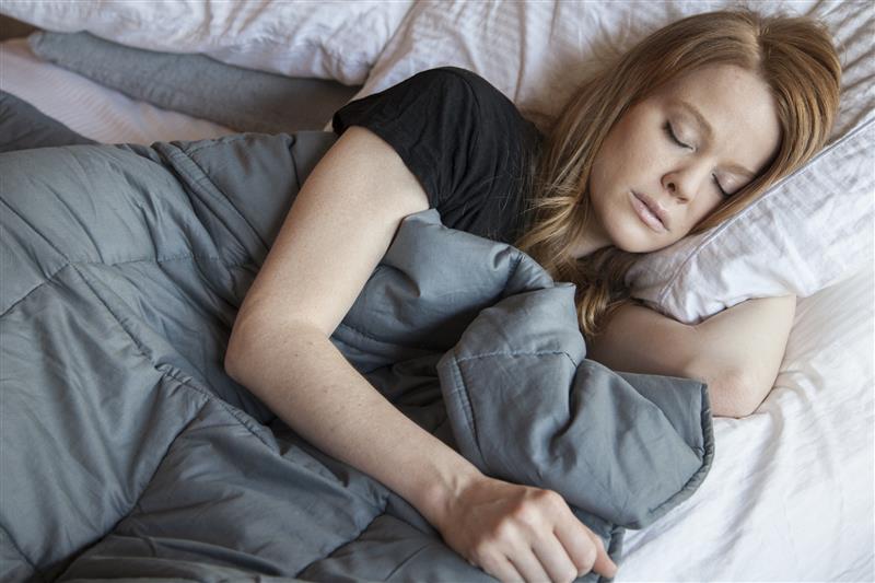 Person sleeping with weighted blanket