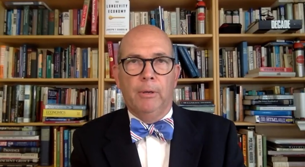 Man-sitting-white-shirt-blue-bowtie-dark-jacket-glasses