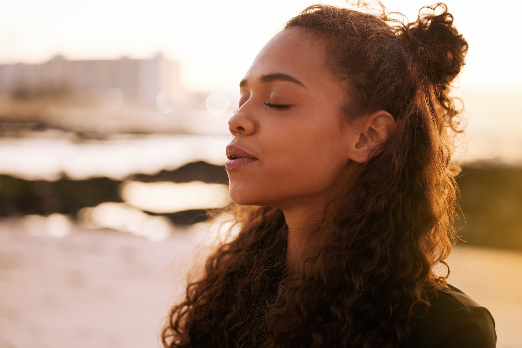 woman-eyes-closed-meditating-outdoors