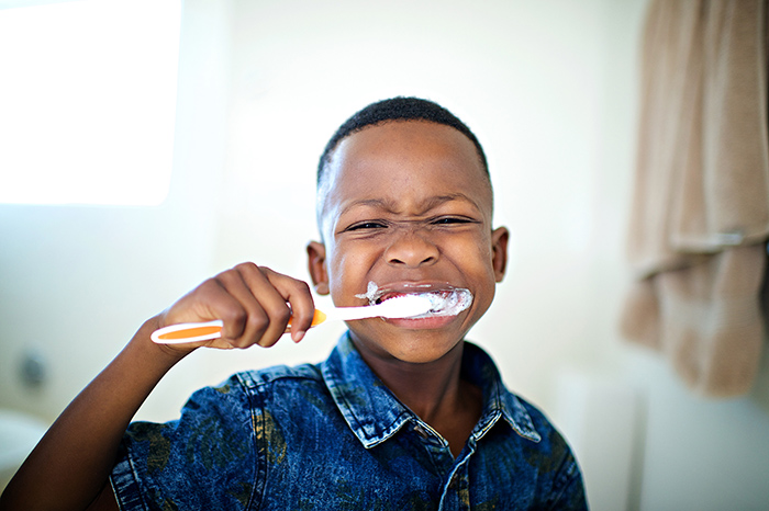 Young boy in bathroom brushing his teeth