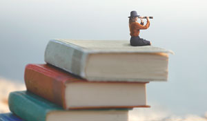 Illustration of person sitting on big stack of books looking through a spyglass.