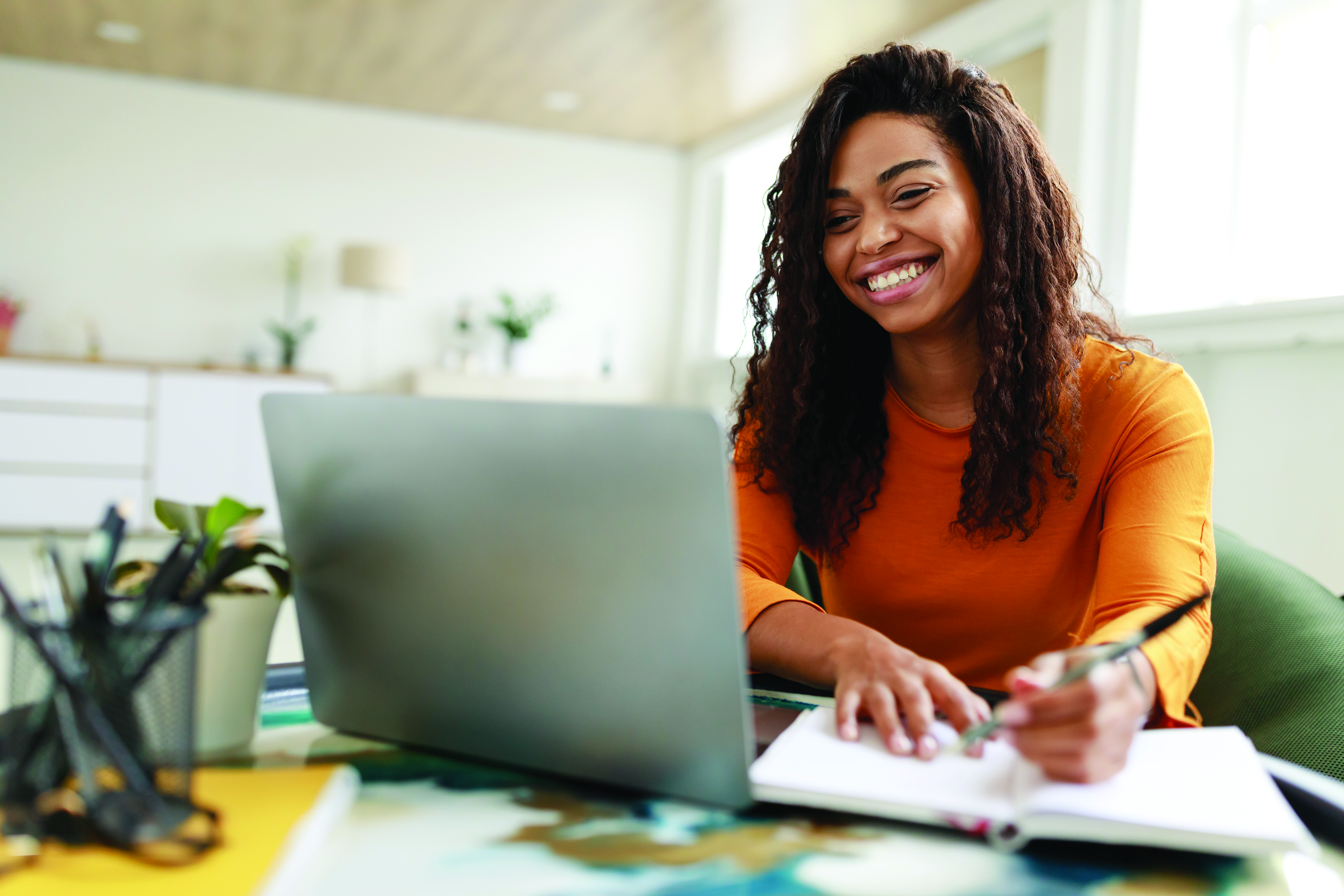 Young woman sitting at a laptop and smiling