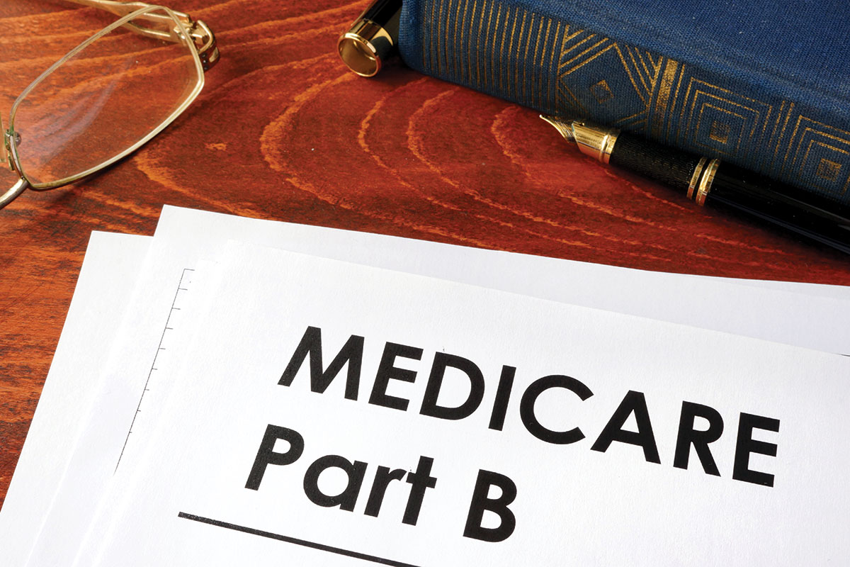 Medicare Part B document sitting on a desk with a pen and glasses