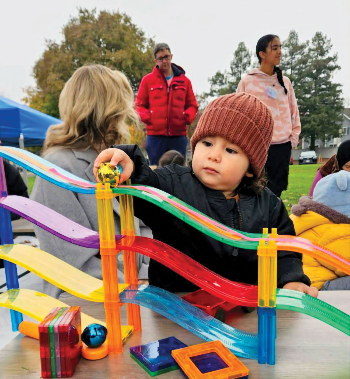Families engaging in hands-on exploration, supporting participation, co-regulation, and shared attention.