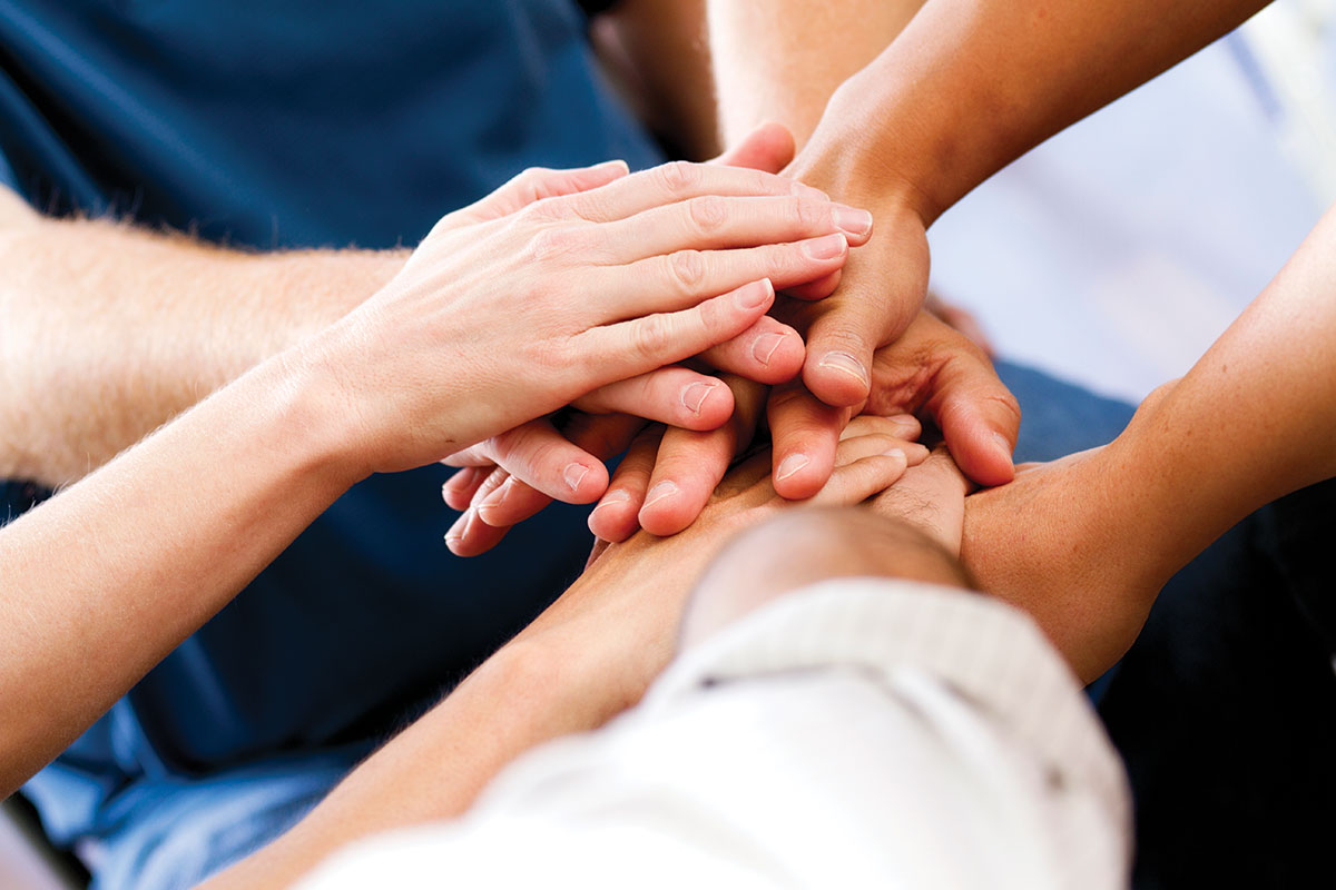 A photo of diverse arms/hands one on top of the other