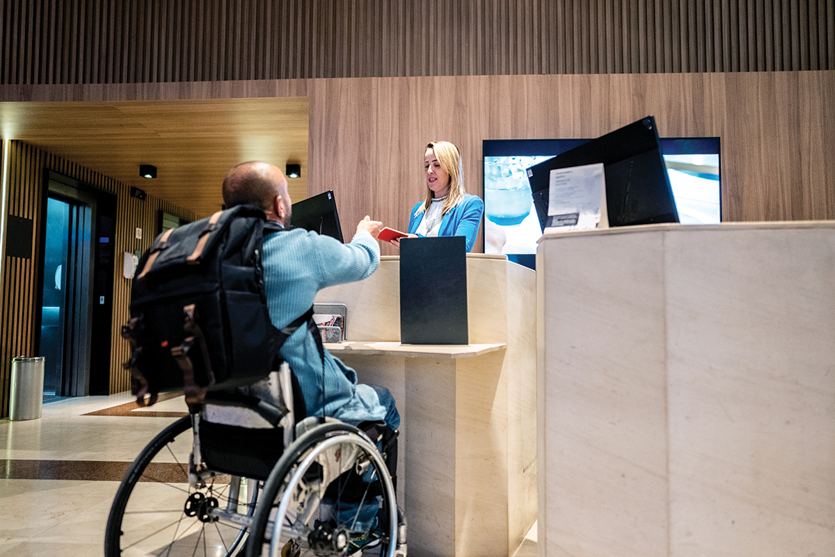 Person in wheelchair checks in at a hotel