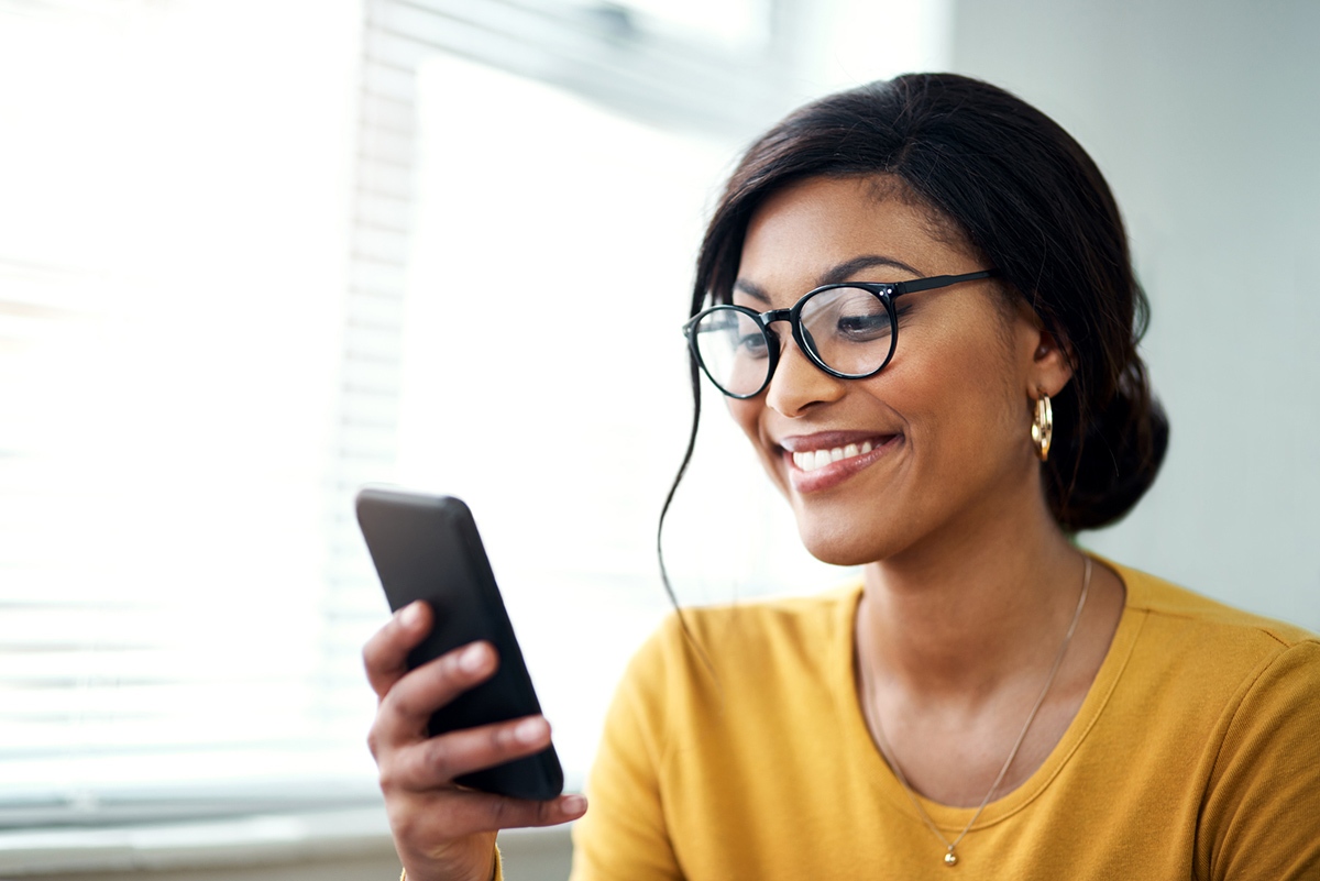 Close up of woman wearing glasses reading her phone