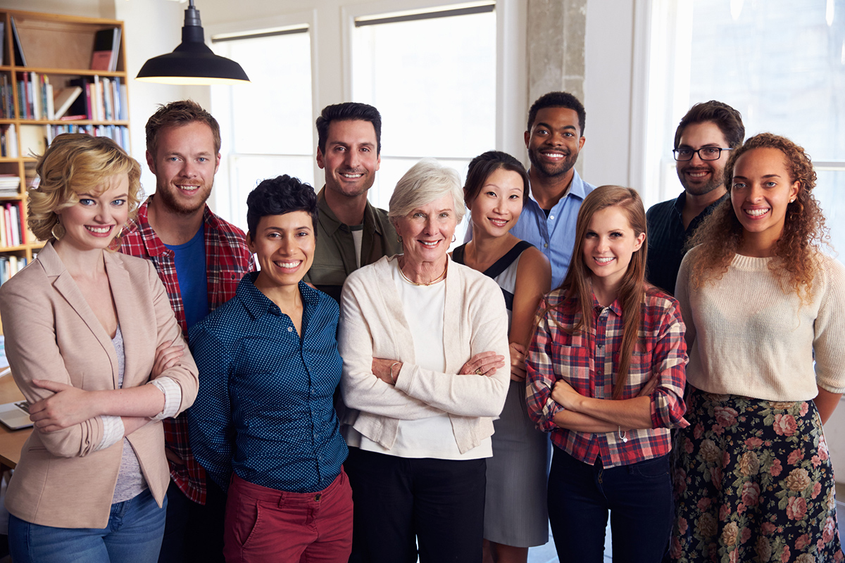Large diverse group of coworkers smiling for camera inside office