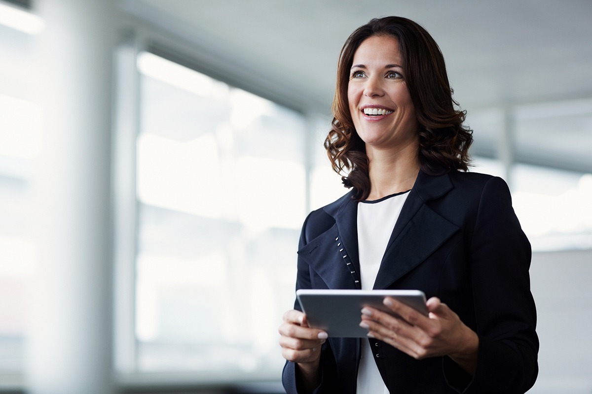Professional woman smiling while holding a tablet