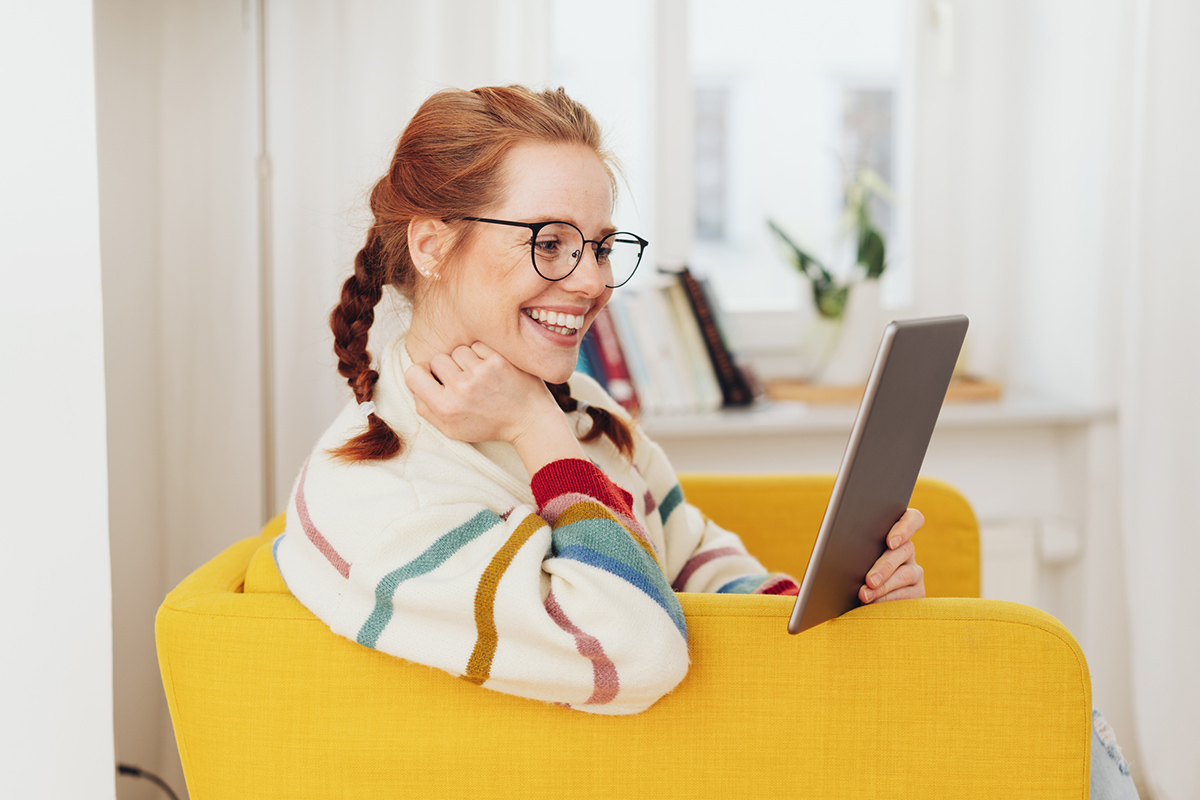 Woman casually sitting in beanbag chair reading a tablet