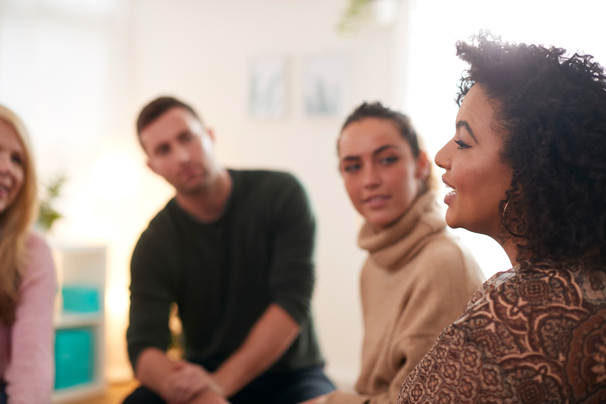 Close up of woman advocating to others in a group setting