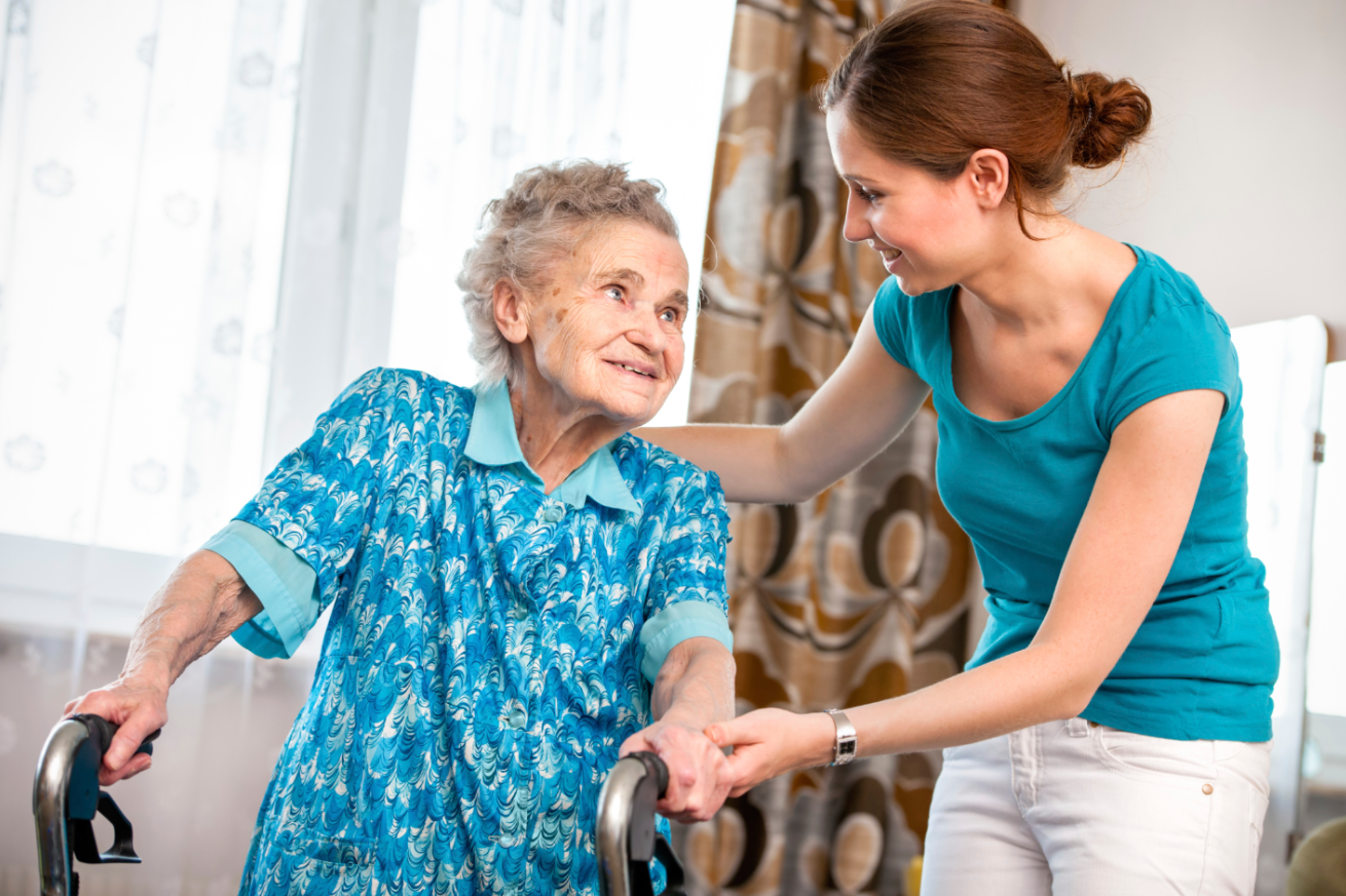 woman using a walker with caregiver