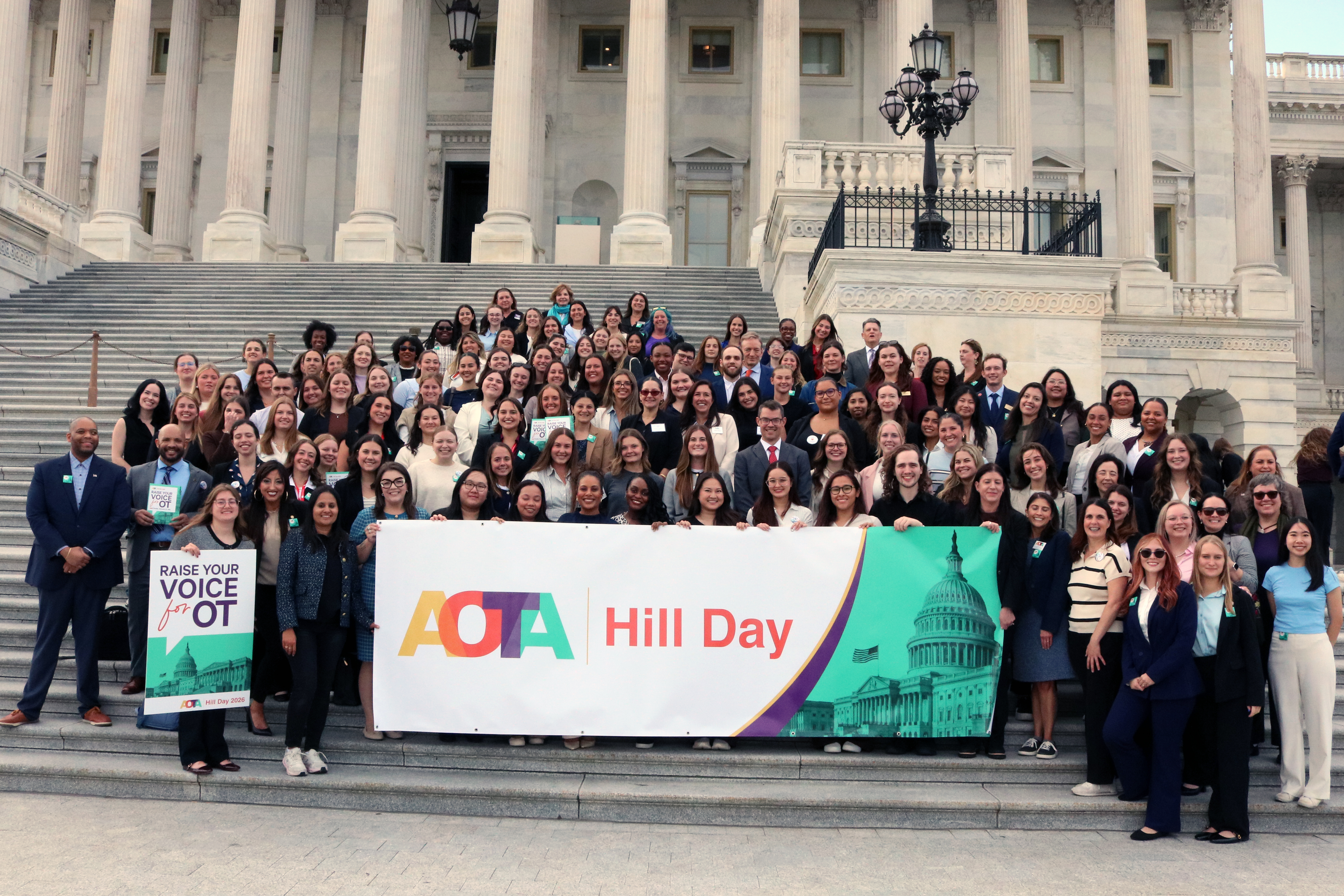 Hill Day 2026 participants on the steps of the Capitol holding AOTA Hill Day Banner.