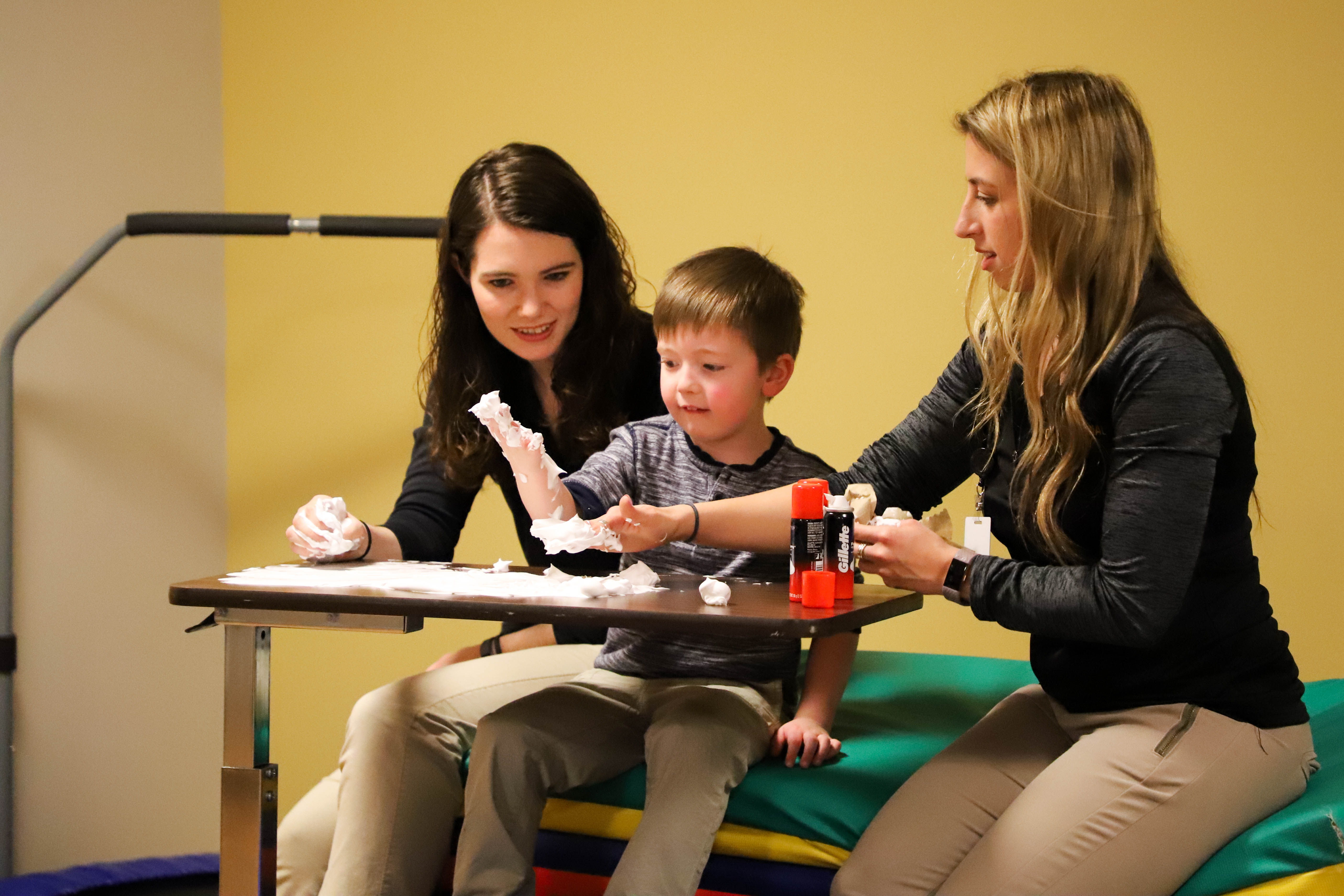 Playing with shaving cream to work on pre-handwriting skills during a therapy session at Little Nights Occupational Therapy Clinic at Gannon University. 