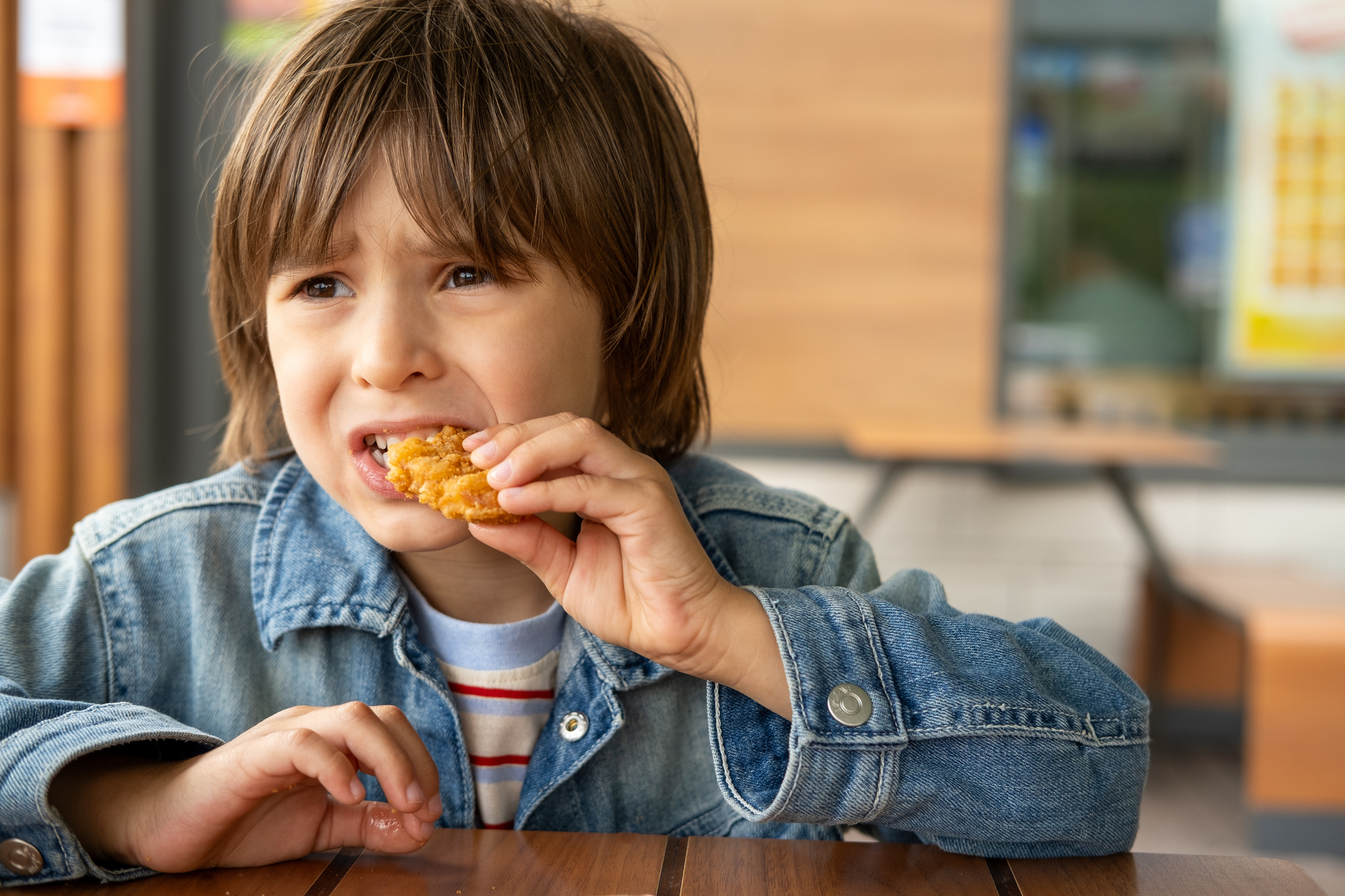 Child sitting at table eating food.
