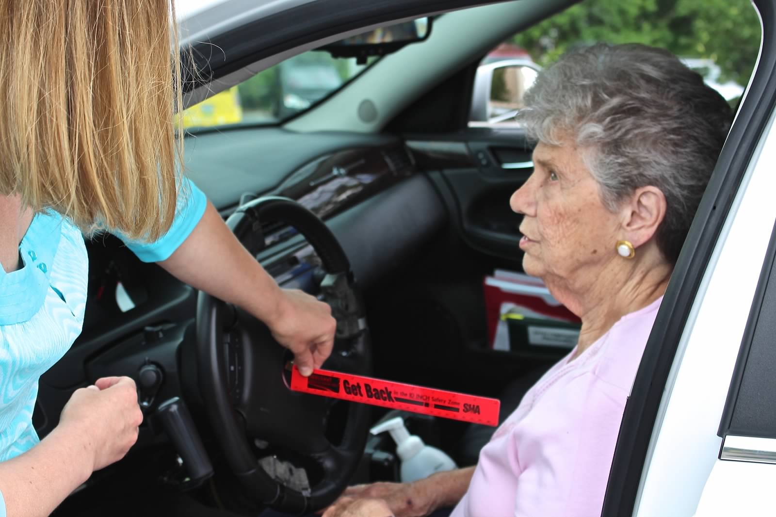 Occupational therapist helps an older driver during a CarFit event