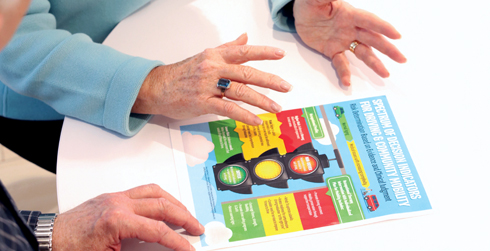 close up of hands touching a transportation themed flyer on a table