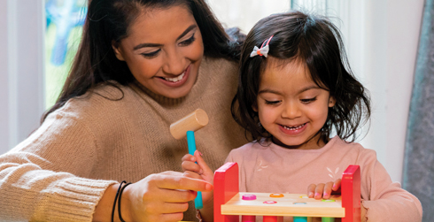 Woman and child playing with a hammer and block toy