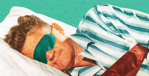 Man sleeping with green and white pajamas and green sleep mask.
